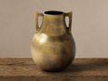 Taddeo Low Pot: Classically shaped antique brass cast aluminum pot with two handles, on a rustic wooden surface.