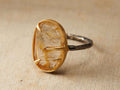 Talieh Ring featuring an oval golden rutilated quartz in a 22 kt gold vermeil setting on an oxidized sterling silver band.