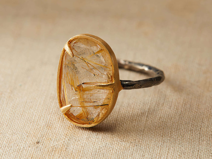 Talieh Ring featuring an oval golden rutilated quartz in a 22 kt gold vermeil setting on an oxidized sterling silver band.