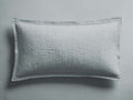 Light blue-grey Tulaya Cotton Sham with a quilted texture and frayed edges, lying flat against a matching background.
