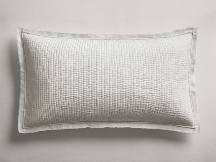 Off-white Tulaya Cotton Sham, horizontally oriented, with a distinct quilted texture and elegant frayed edges.