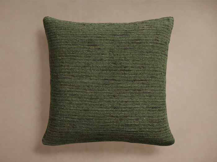 Square Turner Pillow in deep olive green with rich horizontal textured cotton-rayon front on a plain light brown background.