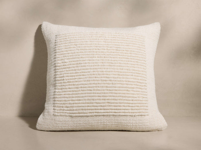 Front view of an off-white cushion with a thick ribbed texture and a raised square border around the central pattern.