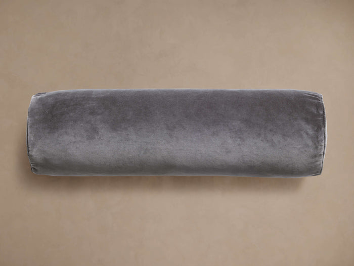Front view of gray velvet bolster cushion, lying horizontally.