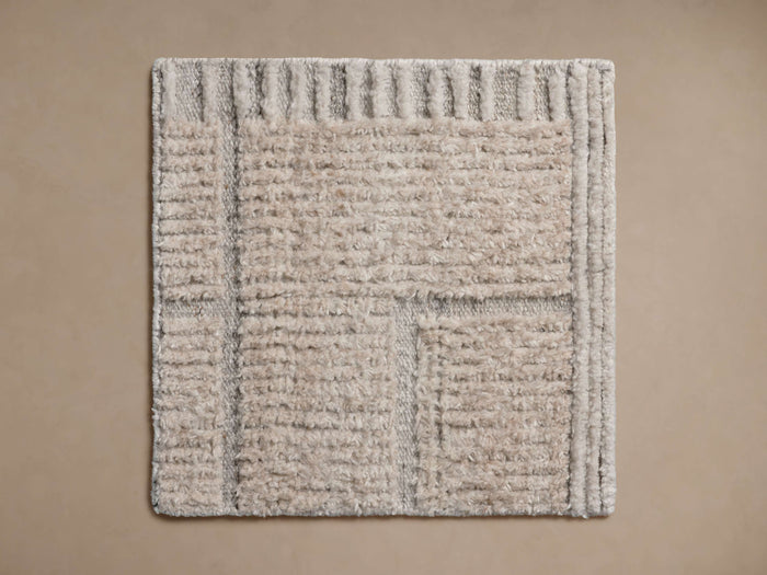 Square Walker Performance Rug Swatch in light beige/grey with varied textures including ribbed borders and a shaggy center.