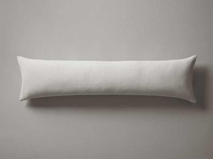 White Washed Waffle Lumbar Pillow Cover on a plain gray background, featuring subtle textured waffle pattern and knife edge detail.