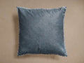Front view of a storm blue square throw pillow with visible cowhide texture and white whipstitch trim around the edges.