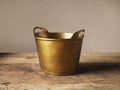 Antiqued brass Wine Chiller Bucket on a rustic wood surface, featuring a textured finish and integrated handles.