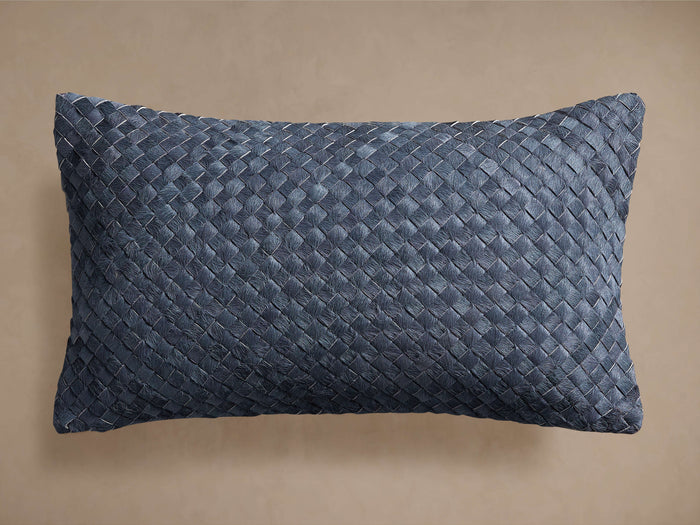 Horizontally oriented blue woven lumbar hide pillow with a prominent basket-weave pattern against a neutral background.