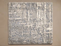 Top-down view of a rectangular rug featuring an abstract textured pattern in light grey, dark grey, and muted blue tones.